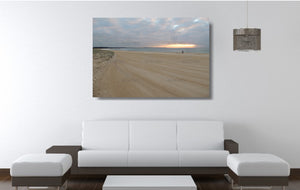 An acrylic print of a fisherman at sunrise at Blacksmiths Beach NSW hanging in a lounge room setting