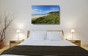 An acrylic print of a perfect sunny day at Blueys Beach NSW hanging in a bed room setting