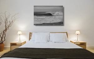 An acrylic print of a wave breaking at Sandon Point NSW hanging in a bed room setting