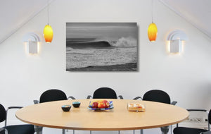 An acrylic print of a wave breaking at Sandon Point NSW hanging in a dining room setting