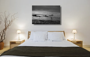 An acrylic print of a surfer entering the water at Golf Course Reef, Mollymook NSW hanging in a bedroom setting
