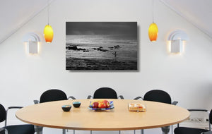 An acrylic print of a surfer entering the water at Golf Course Reef, Mollymook NSW hanging in a dining room setting