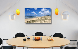 An acrylic print of Main Beach at Point Lookout on North Stradbroke Island QLD hanging in a dining room setting