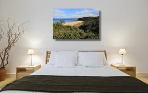 An acrylic print of Rennies Beach in Ulladulla NSW hanging in a bed room setting