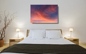 An acrylic print of a soft pastel sunset at Paradise Point QLD in hanging in a bed room setting