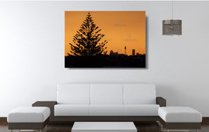 An acrylic print of the Sydney city skyline at sunset in hanging in a lounge room setting