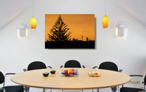 An acrylic print of the Sydney city skyline at sunset in hanging in a dining room setting