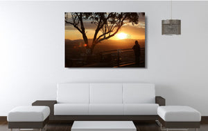 An acrylic print of a lone person standing at a lookout in Tamworth at sunset in hanging in a lounge room setting